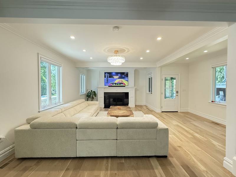 Completed living room renovation with fireplace and open kitchen