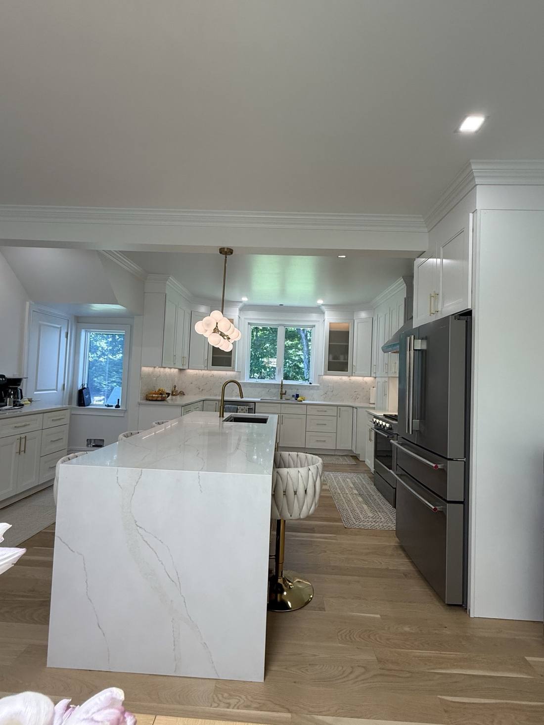 Completed white kitchen with a waterfall island